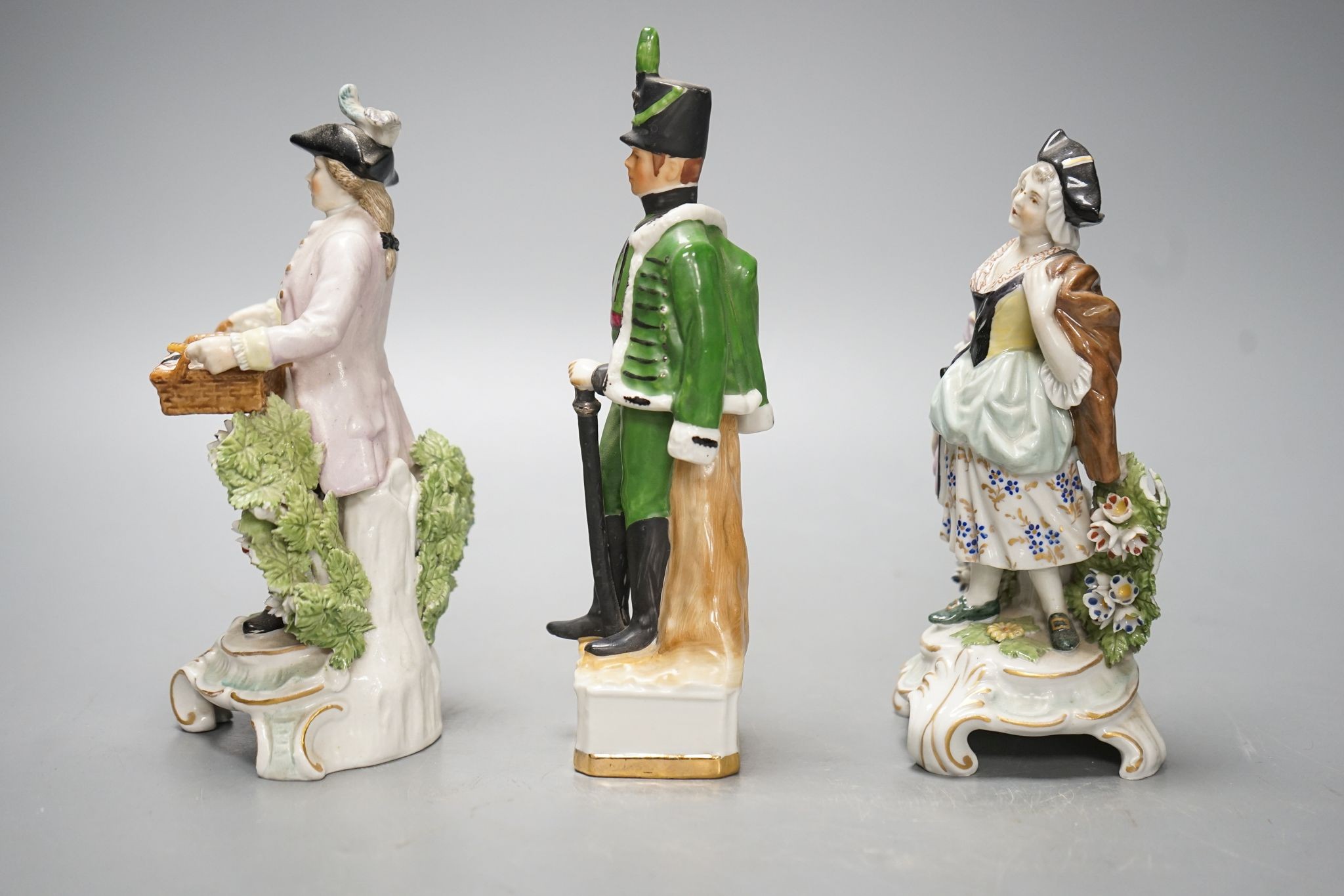 A pair of Dresden porcelain figures of a street-trader and companion and a continental porcelain figure of a Rifle Brigade officer (3) 19.5cm
